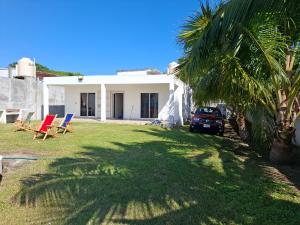 una casa con una palma nel cortile di Casa de Playa Elsa a La Vigueta