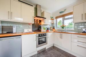 a kitchen with white cabinets and a window at 3 Bed in St. Merryn oc-p00114 in Saint Merryn