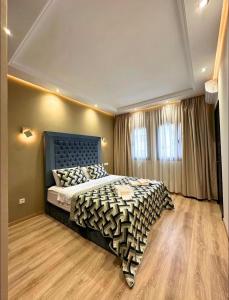 a bedroom with a large bed with a blue headboard at Noble Suite Luxury in Tangier