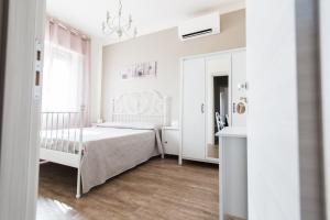 biała sypialnia z białym łóżkiem i oknem w obiekcie Dolce Dormire Civitanova w mieście Civitanova Marche