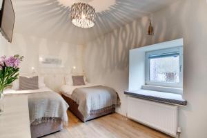 a bedroom with two beds and a window and a chandelier at 3 Bed in Padstow oc-p00793 in Padstow