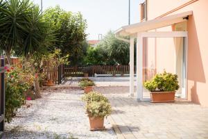 un cortile con piante in vaso e un edificio di Dolce Dormire Civitanova a Civitanova Marche