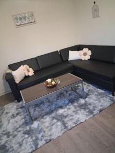 a living room with a black couch and a coffee table at Modern Space Great For Extended Stays Pool & Gym in Burnside East