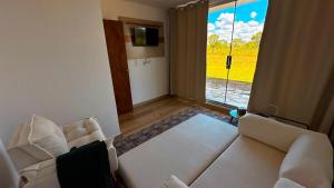 a living room with a white couch and a window at Casa Bela Vista do Cerrado in Samambaia