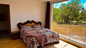 a bedroom with a bed and a large window at Casa Bela Vista do Cerrado in Samambaia