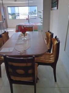 a dining room table with two chairs and a table with flowers on it at Regina in Cabo Frio