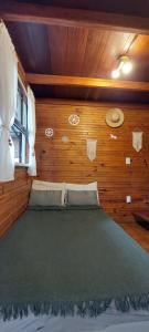 a bedroom with a bed in a wooden wall at Chale Recanto do Lago in Itu +18 photos