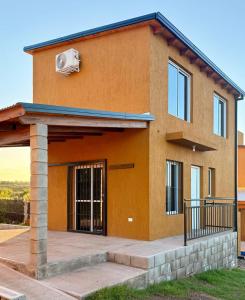 a house with a fan on top of it at Cabañas La Caprichosa in Villa Santa Cruz del Lago