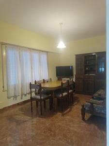 een eetkamer met een tafel, stoelen en een televisie bij Palermo calle 1 in Mar del Tuyú +3 foto's