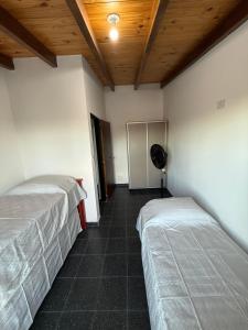 a room with two beds and a fan in it at Cabañas La Caprichosa in Villa Santa Cruz del Lago