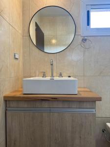 a bathroom with a white sink and a mirror at Cabañas La Caprichosa in Villa Santa Cruz del Lago +11 photos