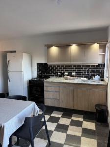 a kitchen with a counter and a refrigerator and a table at Cabañas La Caprichosa in Villa Santa Cruz del Lago