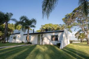 una casa bianca con palme su un prato di La Estancia a Federación