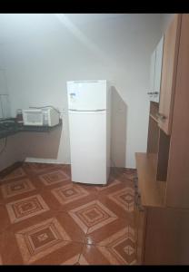 a white refrigerator in a kitchen with a microwave at Casa indisponíve in Maracaju