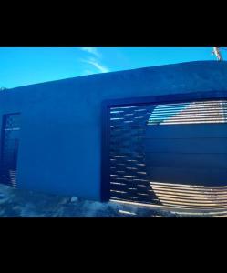 a blue building with a door with a flag on it at Casa indisponíve in Maracaju