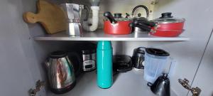 een plank met potten en pannen en andere keukenartikelen bij Chale Recanto do Lago in Itu