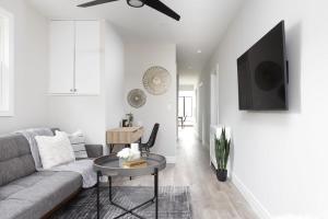 een woonkamer met een bank en een tafel bij New Modern Home in Old Town in Niagara on the Lake