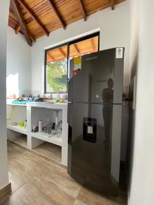 un grand réfrigérateur noir dans une cuisine avec un comptoir dans l'établissement Glamping Esmeralda, à San Gil