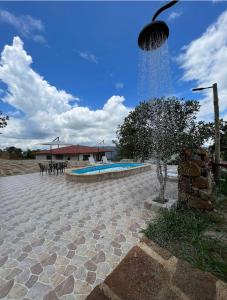 a swimming pool with a fountain in a courtyard at Glamping Esmeralda in San Gil +56 photos