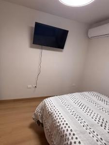 a bedroom with a bed and a flat screen tv on the wall at Residencia Flores in Hermosillo