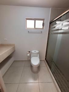 a white bathroom with a toilet and a shower at Residencia Flores in Hermosillo +30 photos
