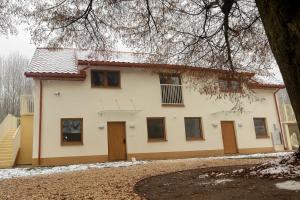 a white house with brown doors and a tree at Apartamenty obok Suntago Park of Poland parking gratis in Wręcza