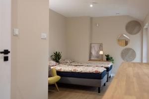 a bedroom with a bed and a yellow chair at Apartamenty obok Suntago Park of Poland parking gratis in Wręcza