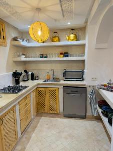 a kitchen with a sink and a stove at Riad Marhaba in Marrakesh