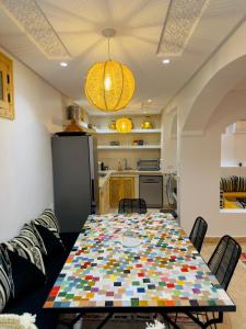a dining room with a table and a kitchen at Riad Marhaba in Marrakesh