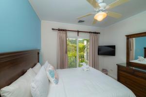 een slaapkamer met een bed, een plafondventilator en een raam bij Del Mar 3C 3 bdr Ocean View in Los Suenos in Herradura +40 foto's