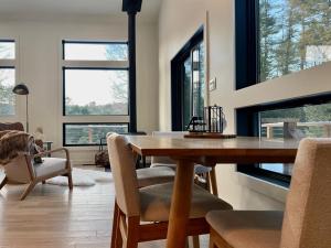 una sala da pranzo con tavolo, sedie e finestre di White Pine Chalet a Yulan