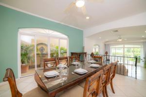 een eetkamer met een lange tafel en stoelen bij Colina 5E 2 bdr Garden View in Los Suenos in Jacó