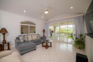 een woonkamer met een bank en een tafel bij Colina 5E 2 bdr Garden View in Los Suenos in Jacó