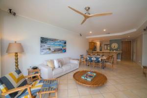 een woonkamer met een bank en een tafel bij Del Mar 4N 3 bdr Garden View in Los Suenos in Herradura