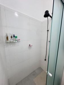 a bathroom with a shower with a glass door at Suite 1 com Ar-Condicionado, TV, Wi-Fi e Geladeira in Jundiaí