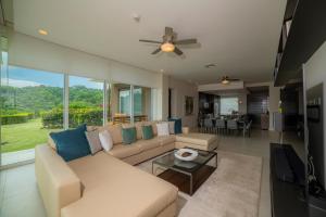 ein Wohnzimmer mit einer Couch und einem Deckenventilator in der Unterkunft Montecielo 3E 3bdrs ocean view in Los Suenos in Herradura