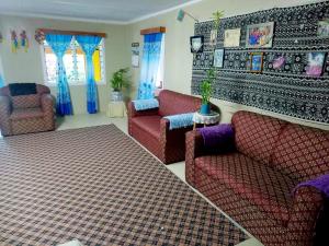 un soggiorno con 2 sedie rosse e un divano di JayDees Home Retreat Homestay a Taveuni