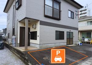宫崎結-musubi-的房子前面有一个停车场，旁边立着停车标志。