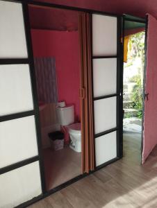 a bathroom with a toilet through a glass door at Marju Glamping in Manizales