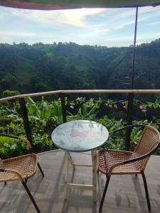 a table and chairs on a balcony with a view at Marju Glamping in Manizales