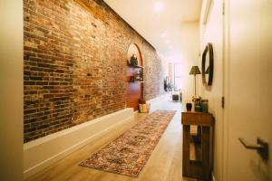 a hallway with a brick wall and a rug on the floor at Historic 2BR suite in Halifax w Free Parking in Halifax +23 photos