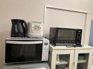 a microwave and a toaster oven on a table at 202basichostel in Osaka
