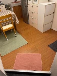 a kitchen with a table and a chair and a kitchen floor at 202basichostel in Osaka +20 photos