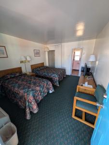 a hotel room with two beds and a desk at Relax Inn in New Castle +8 photos
