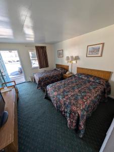 ein Hotelzimmer mit zwei Betten und einem Fernseher in der Unterkunft Relax Inn in New Castle + 8 Fotos