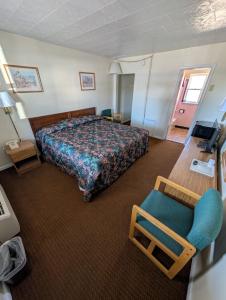 a hotel room with a bed and a chair at Relax Inn in New Castle