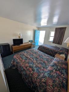 ein Hotelzimmer mit zwei Betten und einem Fernseher in der Unterkunft Relax Inn in New Castle