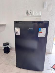 een zwarte koelkast op een tegelvloer bij SuÍte 4 Completa com Wi-Fi e Netflix in Jundiaí +7 foto's
