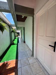 een gang van een huis met een deur en gras bij SuÍte 4 Completa com Wi-Fi e Netflix in Jundiaí