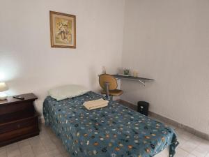 een slaapkamer met een bed, een bureau en een stoel bij SuÍte 4 Completa com Wi-Fi e Netflix in Jundiaí